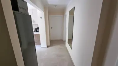 a kitchen with a stainless steel refrigerator and a hallway at Apartment Katamaran in Kraków