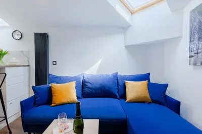 a blue couch with yellow pillows in a living room at Downtown Apartments Cracow in Kraków