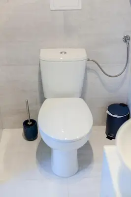 a white toilet in a bathroom with a hose at Downtown Apartments Cracow in Kraków
