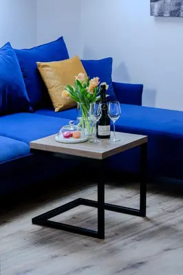 a coffee table with a bottle of wine and a vase of flowers at Downtown Apartments Cracow in Kraków