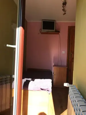a room with a bed and a television on a shelf at Malinowy Domek in Młyńczyska