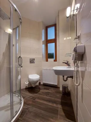 a bathroom with a toilet and a sink and a shower at Atlantic Aparthotel in Kraków