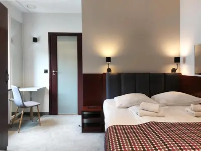 a bedroom with a bed and a desk and a chair at Atlantic Aparthotel in Kraków
