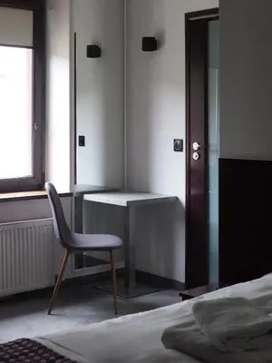 a bedroom with a chair and a desk and a bed at Atlantic Aparthotel in Kraków