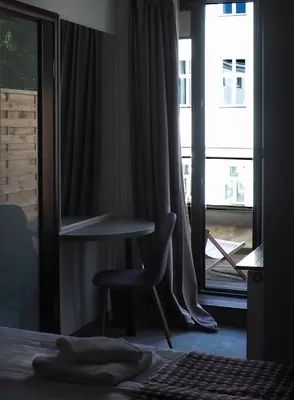 a bedroom with a chair in front of a window at Atlantic Aparthotel in Kraków