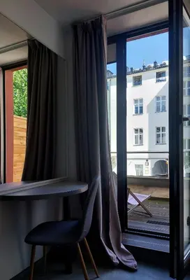 a room with a window with a table and a chair at Atlantic Aparthotel in Kraków
