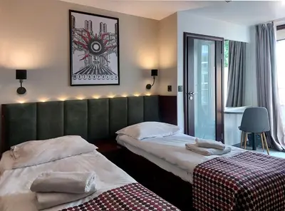 a hotel room with two beds and a window at Atlantic Aparthotel in Kraków