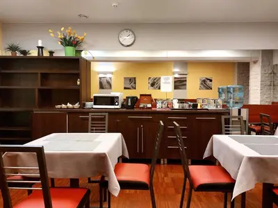 a restaurant with two tables and a counter with a microwave at Atlantic Aparthotel in Kraków