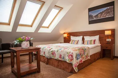 a bedroom with a bed and two chairs and a mirror at Chochołowy Dwór in Jerzmanowice