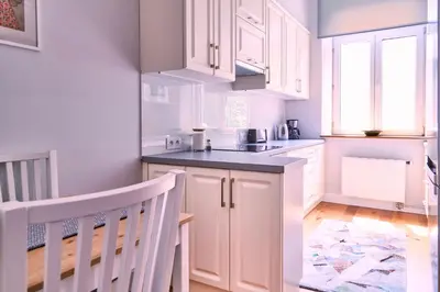 a kitchen with white cabinets and a sink at Kraków Old Town 2 bedroom royal apartment in Kraków