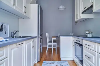 a kitchen with white cabinets and blue counter tops at Kraków Old Town 2 bedroom royal apartment in Kraków