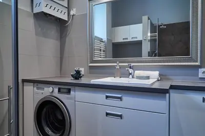 a bathroom with a washing machine and a sink at Kraków Old Town 2 bedroom royal apartment in Kraków