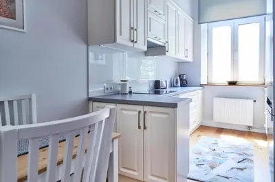 a kitchen with white cabinets and a sink at Kraków Old Town 2 bedroom royal apartment in Kraków