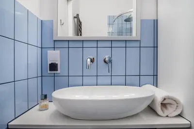 a bathroom with a white sink and blue tiles at MB Cracow Apartments in Kraków