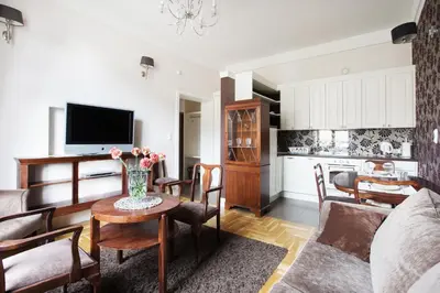a living room with a vase of flowers on a table at MB Cracow Apartments in Kraków