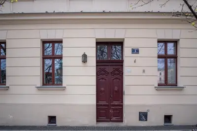 a white building with a brown door and windows at MB Cracow Apartments in Kraków