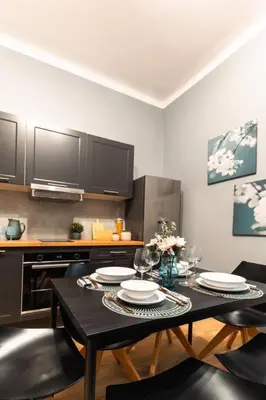 a kitchen with a table with plates and wine glasses at Home far from Home in Kraków