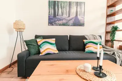 a living room with a black couch and a table at Home far from Home in Kraków