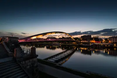 a large bridge over a river at night at Home far from Home in Kraków