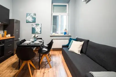 a living room with a black couch and a table at Home far from Home in Kraków