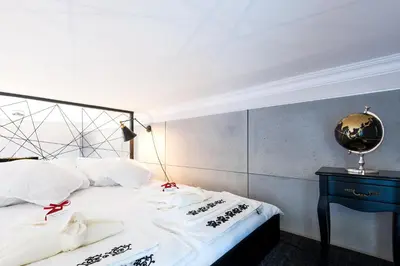 a bedroom with a bed with white sheets and a blue table at Home far from Home in Kraków