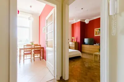 a room with red walls and a dining room at Fantasia Apartments in Kraków