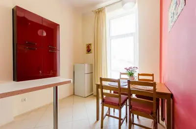 a kitchen with a table and chairs and a red cabinet at Fantasia Apartments in Kraków
