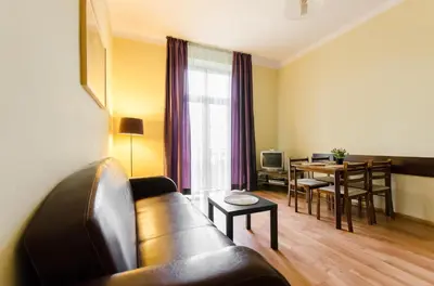 a living room with a couch and a table at Fantasia Apartments in Kraków