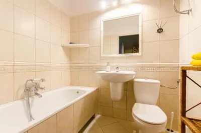 a bathroom with a toilet and a sink and a bath tub at Fantasia Apartments in Kraków
