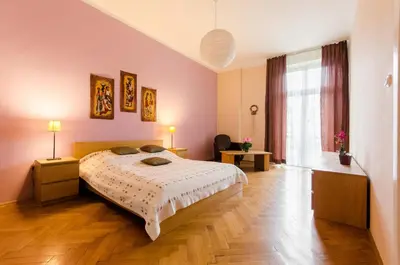 a bedroom with a large bed and a large window at Fantasia Apartments in Kraków