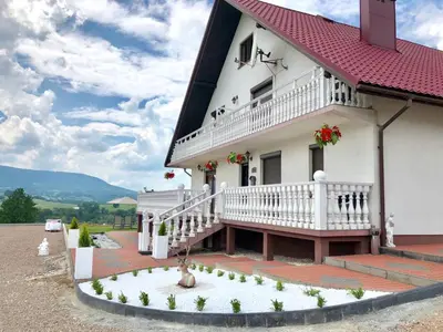 a white house with a red roof at Grand Panorama in Wiśniowa