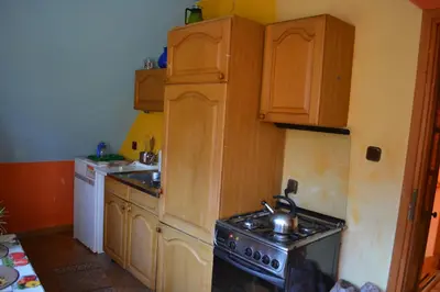 a kitchen with wooden cabinets and a stove top oven at Agroturystyka Oblica in Zawoja