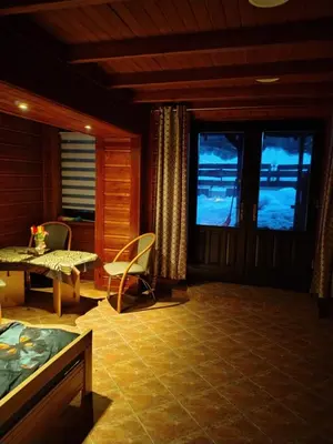 a living room with a table and chairs and windows at Agroturystyka pod Pstragiem in Zawoja