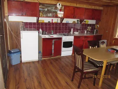 a kitchen with a table and a white stove top oven at Agroturystyka pod Pstragiem in Zawoja