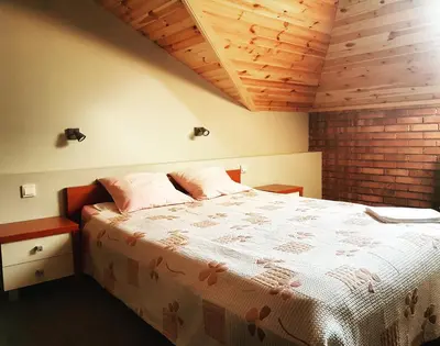 a bedroom with a large bed with a wooden ceiling at Zajazd Złota Rybka in Andrychów