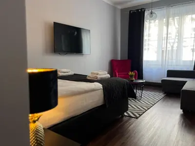 a living room with a bed and a tv at Leo Apartments Old Town in Kraków