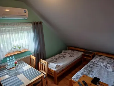 a room with two beds and a table and a dining room at Willa Orle Gniazdo in Biały Kościół