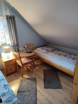 a bedroom with a bed and a table and a bed and a table at Willa Orle Gniazdo in Biały Kościół
