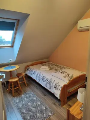 a small bedroom with a bed and a table at Willa Orle Gniazdo in Biały Kościół
