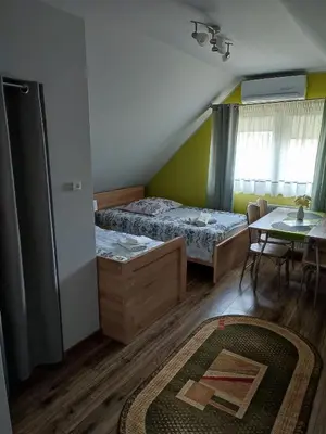 a small bedroom with two beds and a table at Willa Orle Gniazdo in Biały Kościół