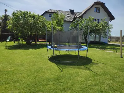 a swing set in a yard with a house at Willa Orle Gniazdo in Biały Kościół