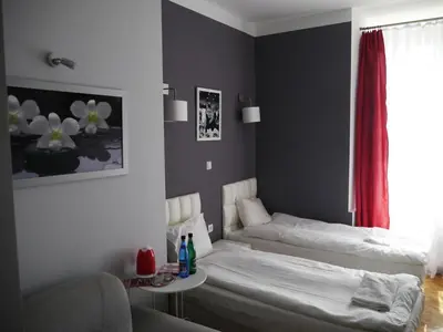 a kitchen with a table and four red chairs at Residence B&B La Fontaine Aparthotel in Kraków