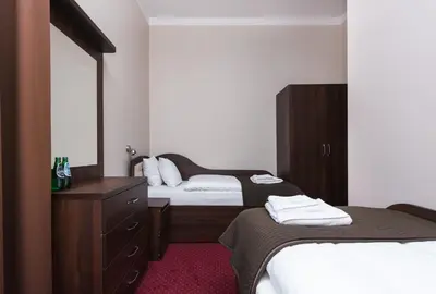 a bedroom with two beds and a dresser and a mirror at Rembrandt Aparthotel in Kraków