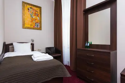 a bedroom with a bed with a dresser and a mirror at Rembrandt Aparthotel in Kraków