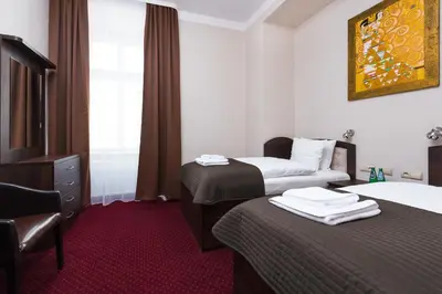 a hotel room with two beds and a window at Rembrandt Aparthotel in Kraków