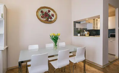 a dining room with a white table and white chairs at Rembrandt Aparthotel in Kraków