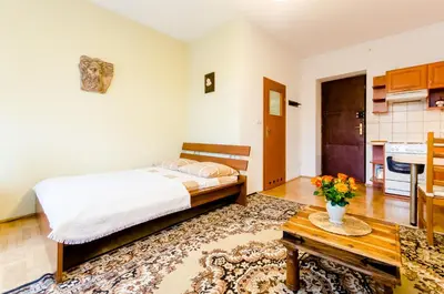 a bedroom with a bed and a table at Central Krak Apartments - studios in Kraków