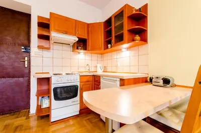 a kitchen with wooden cabinets and a counter top at Central Krak Apartments - studios in Kraków