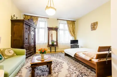 a bedroom with a bed and a couch and a table at Central Krak Apartments - studios in Kraków