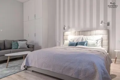 a bedroom with a large bed and a couch at Mateyko Apartment in Kraków